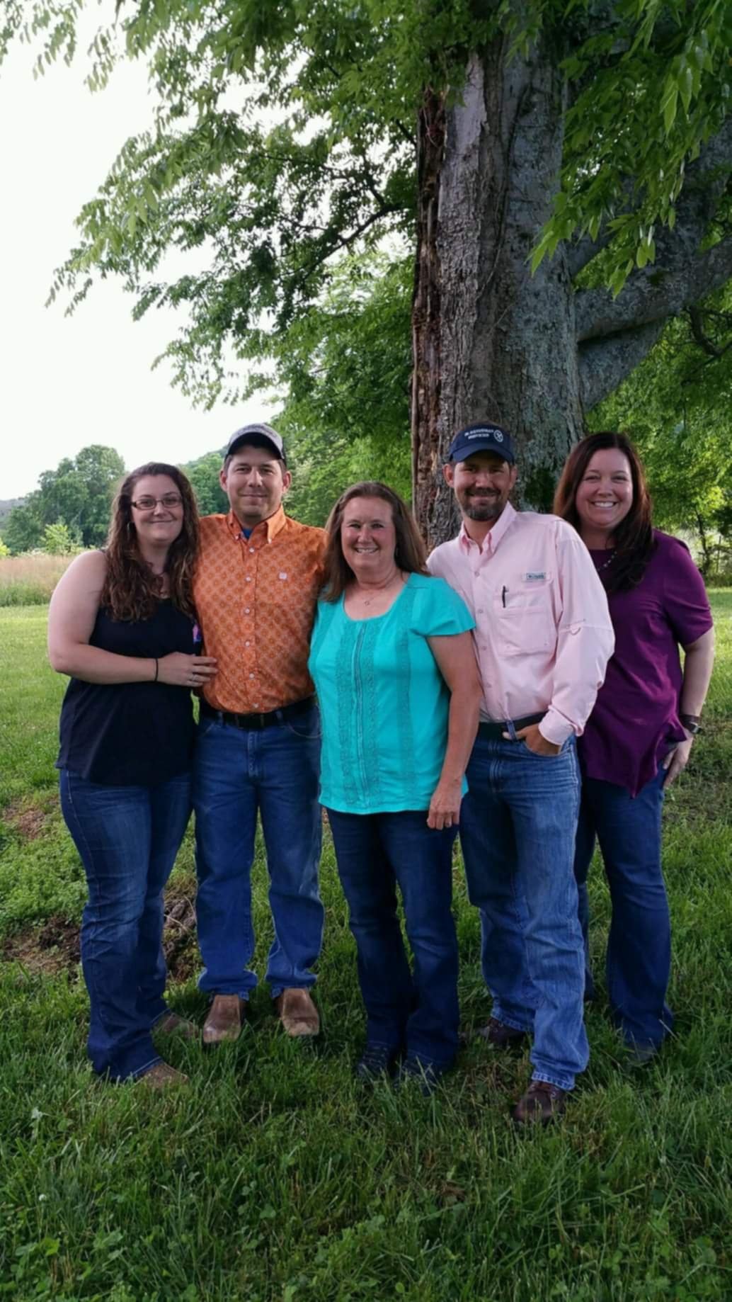 Adam Lazenby with his extended family gathered outdoors under a beautiful tree, showing the large support network that loves him