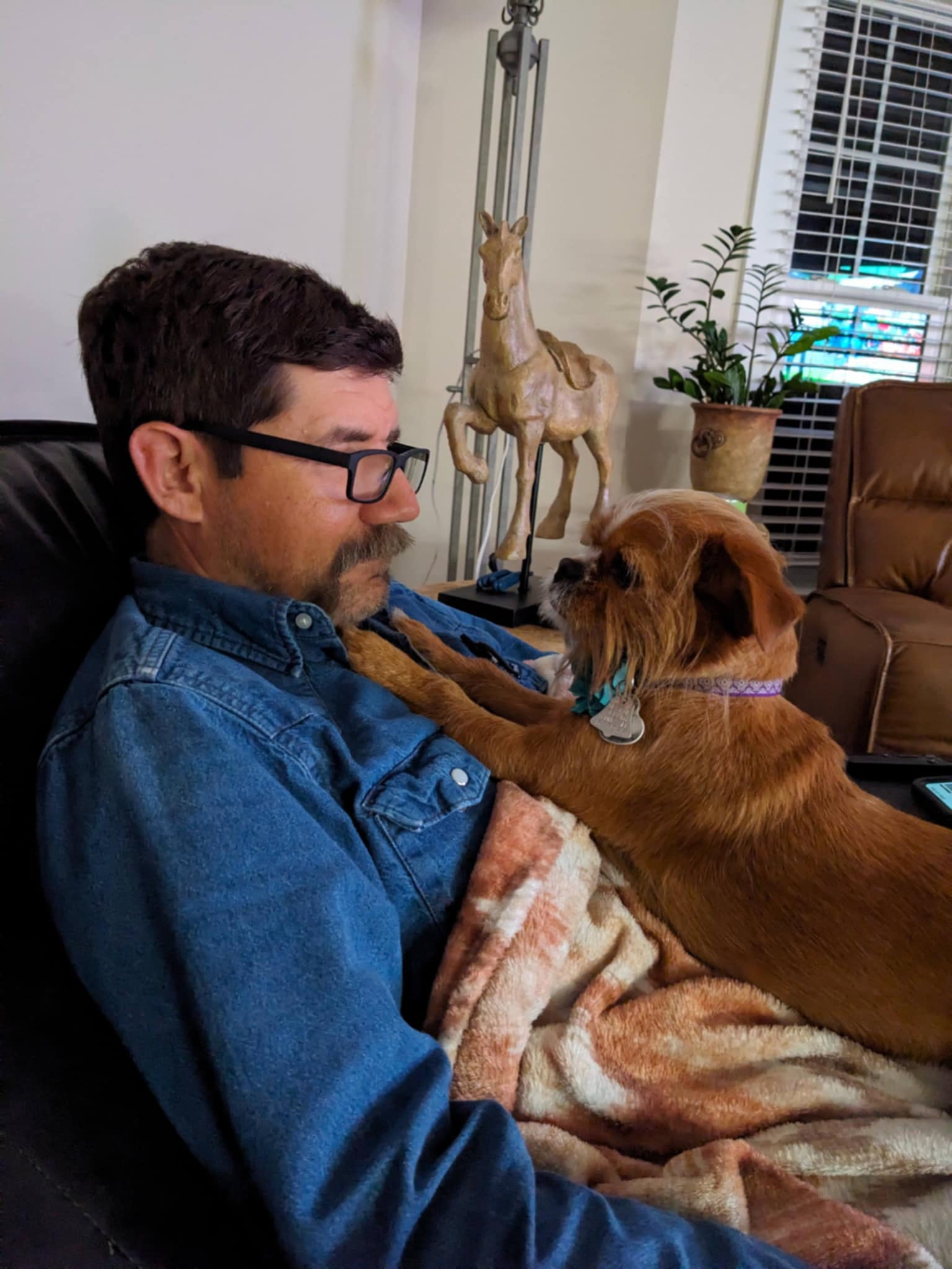 Adam Lazenby cuddling with his beloved dog Hazel, showing the special bond between them